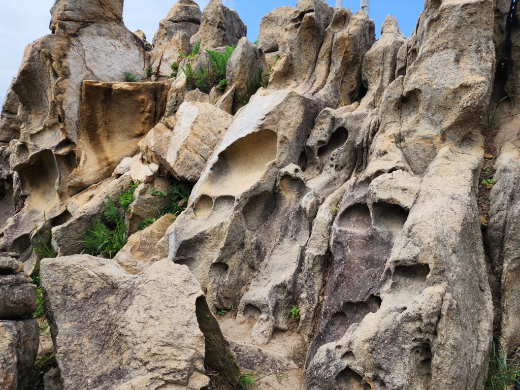 Vertical shots of hollowed rock windows and towering granite formations at Neungpadae.