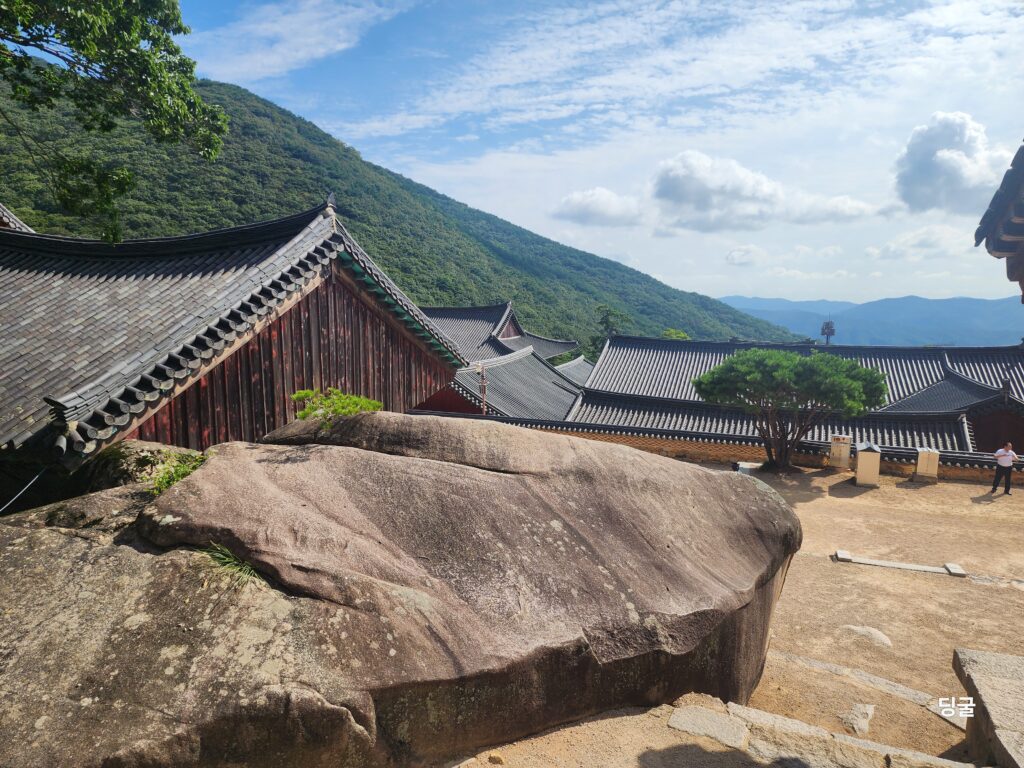Traditional Korean tiled roofs of Beomeosa Temple nestled against the green peaks of Geumjeongsan Mountain.
