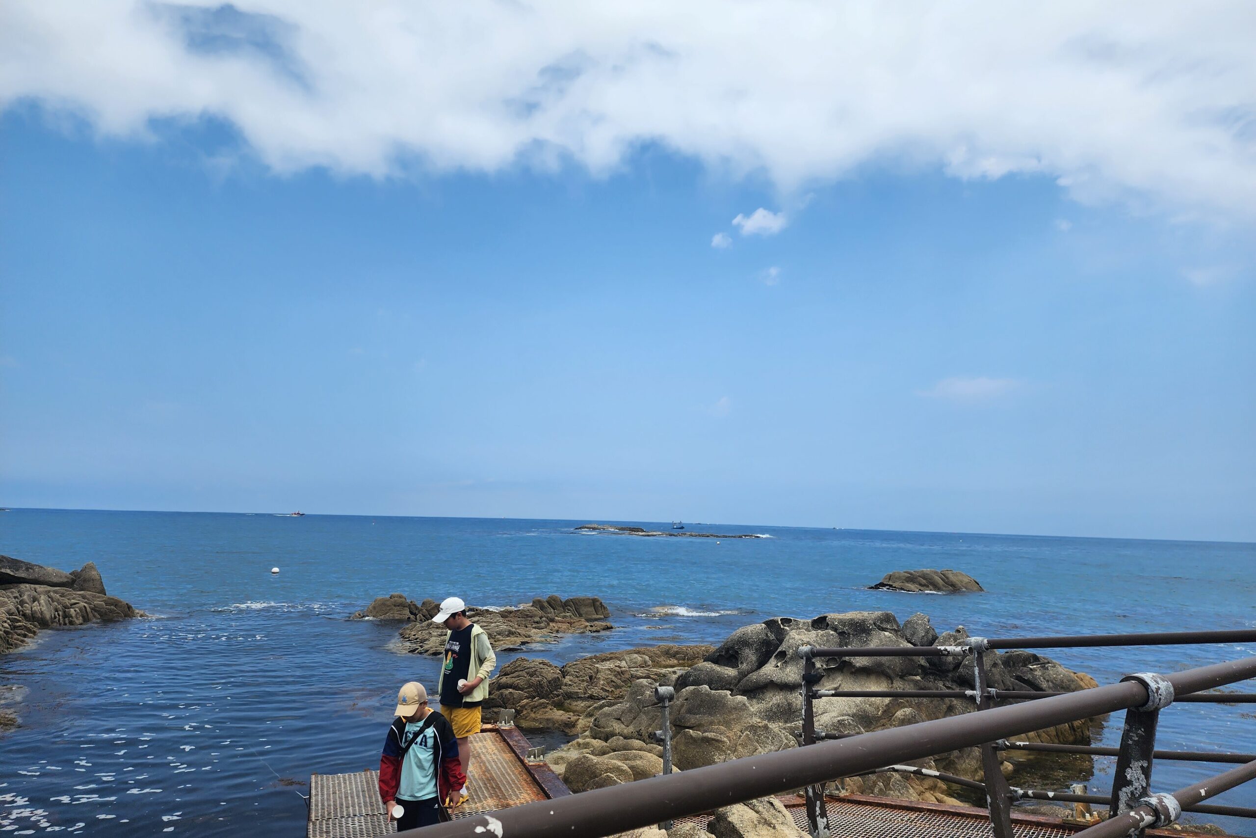 Travelers walking on the wooden boardwalk trail along the ocean at Neungpadae Goseong.
