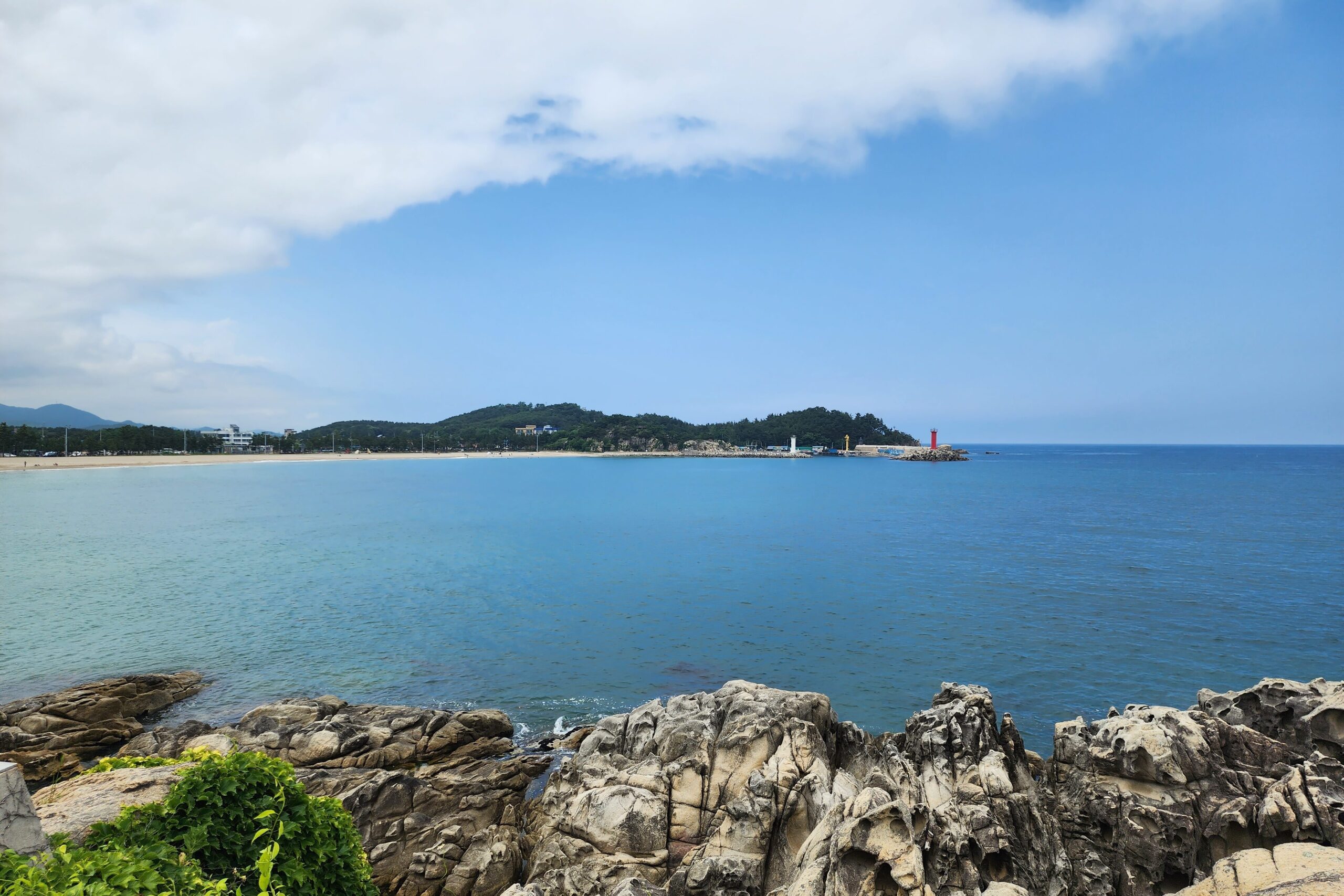 Scenic view of the rocky coastline and blue ocean under a partly cloudy sky at Goseong Gangwon-do.