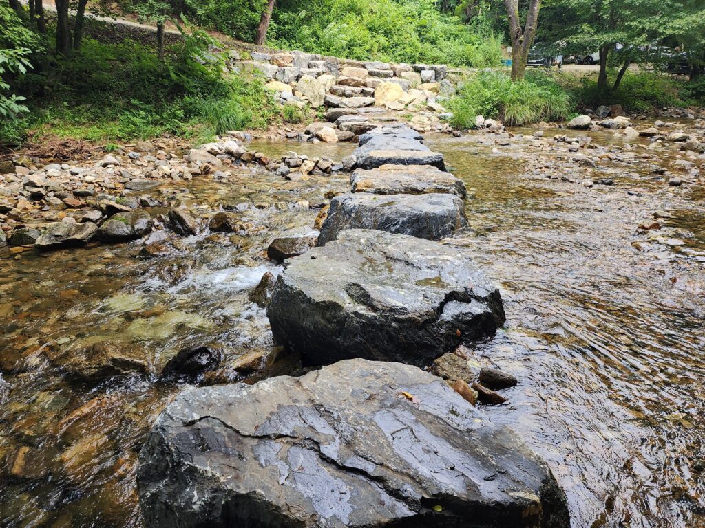 Stepping stone path crossing over a clear, shallow mountain stream in South Korea.