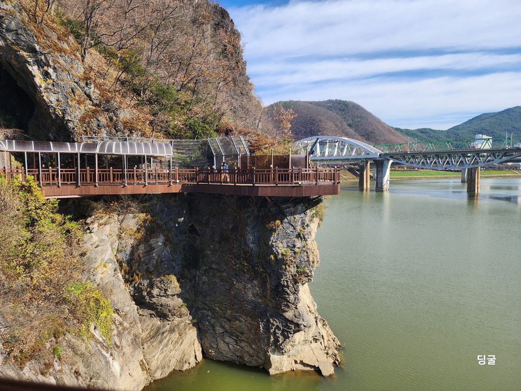 A wooden cantilever bridge of the Danyang River Trail built along a steep cliff with a river view.