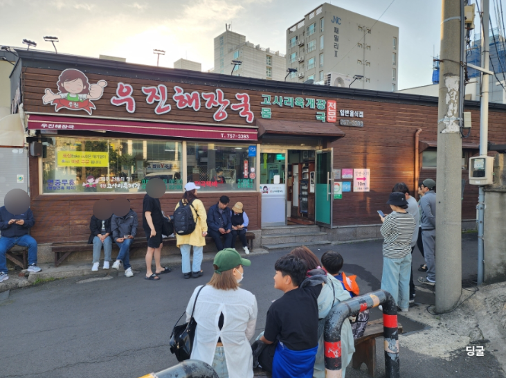 Exterior view of Ujin Haejangguk, a traditional restaurant with a long line.